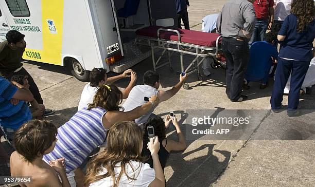 People take pictures with their mobile phones of Argentinian River Plate's forward Diego Buonanotte after he arrived in an ambulance to be...