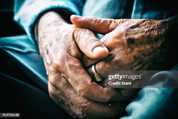ältere mann sitzen auf stuhl und cross-arme - sad old man stock-fotos und bilder