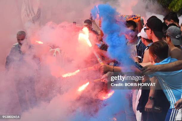 Marseille supporters burn flares and cheer as they gather to attend the team's training session at the Robert-Louis Dreyfus training center on May 2,...