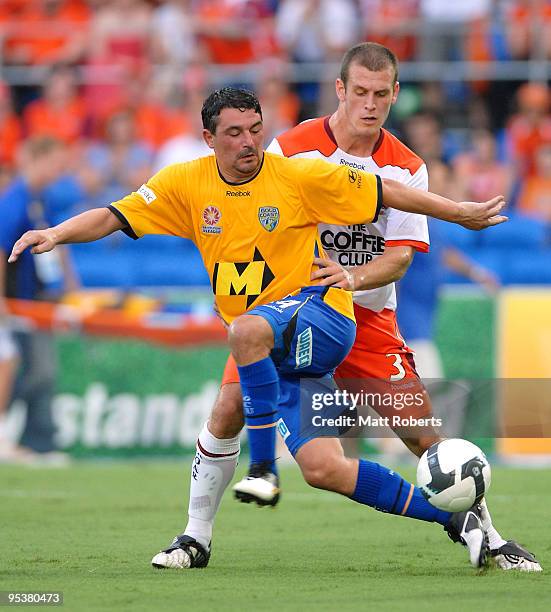 Charlie Miller of United contests the ball with Luke Devere during the round 21 A-League match between Gold Coast United and Brisbane Roar at Skilled...