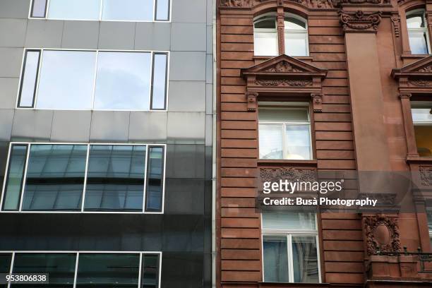 contrast between facades of an old, pre war residential building, and a new apartment complex in berlin (germany), district of mitte. - gentrification stock pictures, royalty-free photos & images
