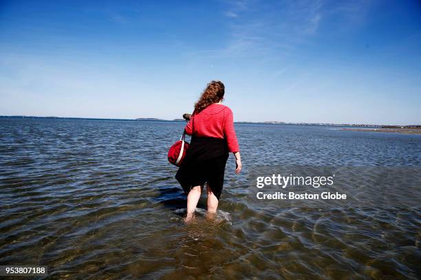 Lisa Quigley of Somerville wades into the water at Wollaston Beach in Quincy, MA on April 24, 2018.