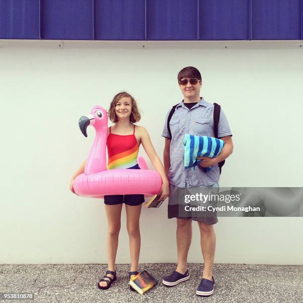 dad and daughter and inflatable flamingo - embarrased dad stockfoto's en -beelden