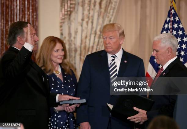 Vice President Mike Pence swears in Secretary of State Mike Pompeo , as his wife Susan holds a bible with President Donad Trump standing nearby...