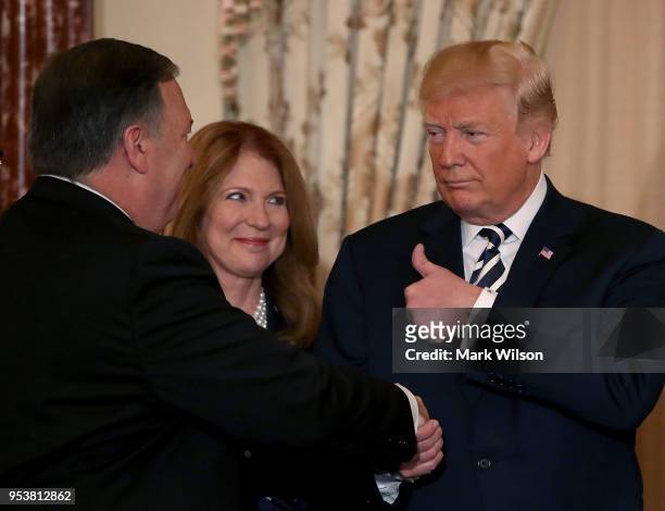 President Donald Trump congratulates Secretary of State Mike Pompeo and his wife Susan Pompeo stand nearby, during a ceremonial swearing in at the...