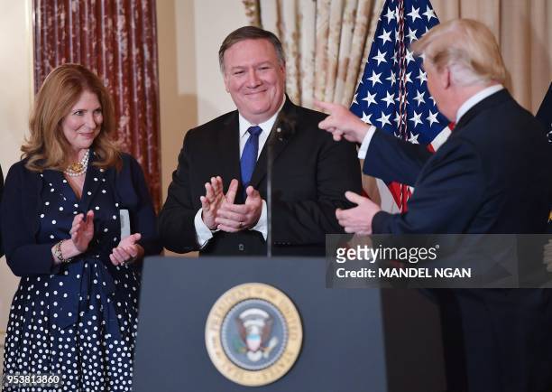 President Donald Trump points to US Secretary of State Mike Pompeo while Pompeo's wife Susan applauds during his ceremonial swearing-in at the State...