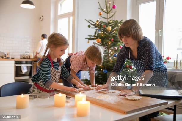 modern mother making cookies with daughter and son at christmas - kids advent stock pictures, royalty-free photos & images
