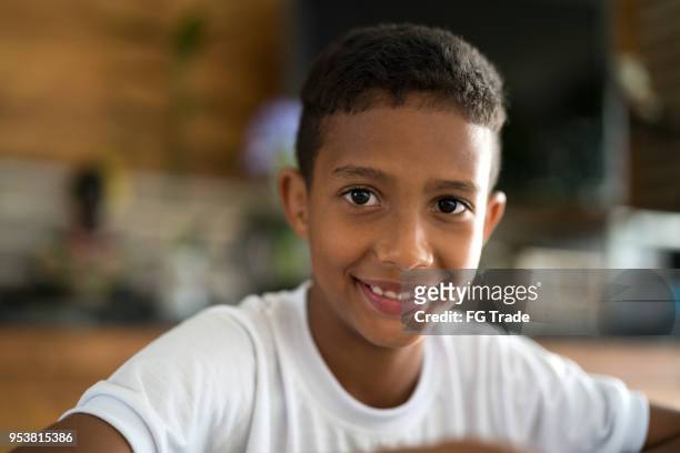 schattige afro jongen camera kijken - colombiaanse etniciteit stockfoto's en -beelden