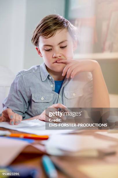10 years old blonde school boy while doing homework. - 10 11 years boy stockfoto's en -beelden