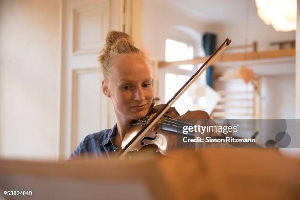 caucasian woman playing the violin at home - violino foto e immagini stock