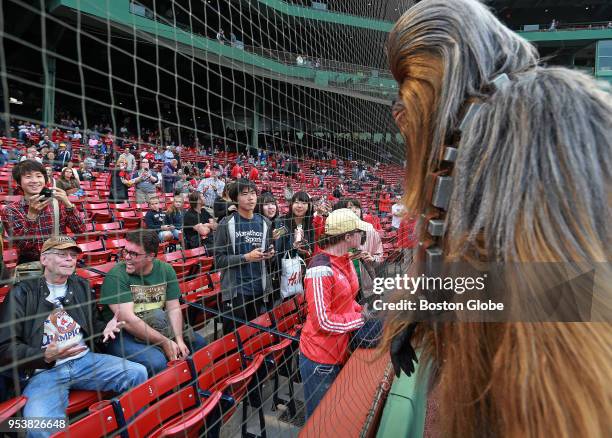 Novelist Stephen King, far left in stands, has a silent interaction with an actor dressed as Star Wars character Chewbacca before the start of the...