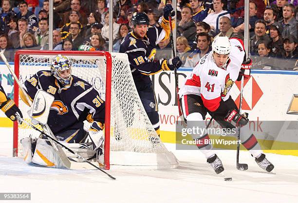 Ryan Miller and Tim Connolly of the Buffalo Sabres try to stop the wrap around scoring attempt of Jonathan Cheechoo of the Ottawa Senators on...