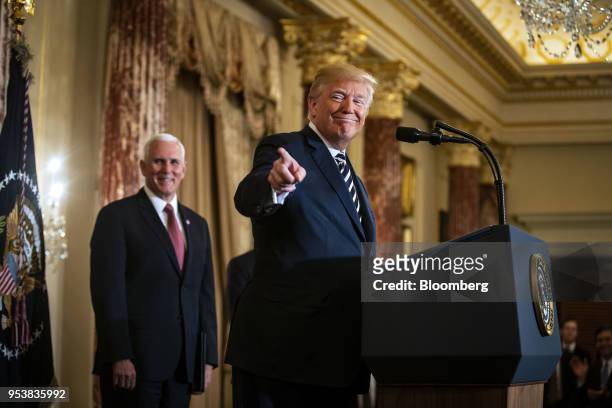 President Donald Trump, points while speaking as U.S. Vice President Mike Pence, left, listens during a swearing in ceremony for Mike Pompeo, U.S....