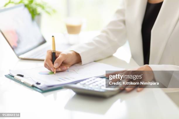 close up hands of businessman working with business document and laptop on the table. - low stock-fotos und bilder