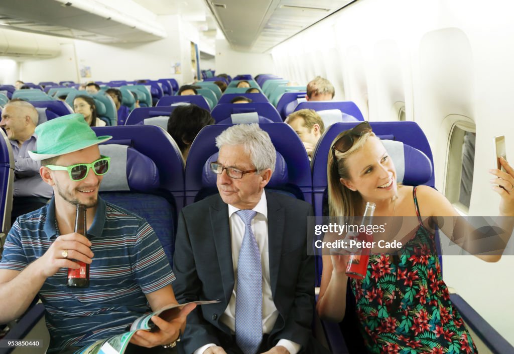 Annoyed man on airplane between young adults