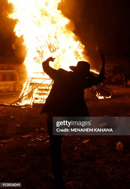 An Ultra-Orthodox Jew dances around a bonfire in Jerusalem's Ultra-Orthodox Mea Shearim neighbourhood on May 2 during celebrations for the Jewish...