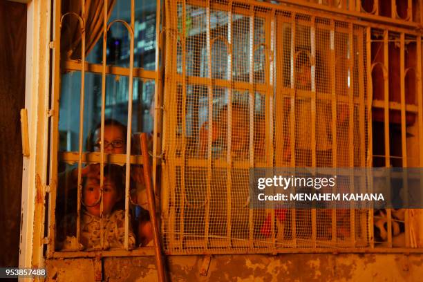 Children look out from a window at a bonfire in Jerusalem's Ultra-Orthodox Mea Shearim neighbourhood on May 2 during celebrations for the Jewish...