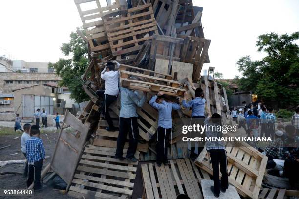 Ultra-Orthodox Jewish children climb up a bonfire to be lit in the evening in Jerusalem's ultra-Orthodox Mea Shearim neighbourhood on May 2 to...