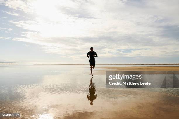 male athlete on beach at sunrise - matthew hale fotografías e imágenes de stock