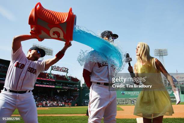 Hector Velazquez of the Boston Red Sox douses Mookie Betts as he is interviewed after the Boston Red Sox defeated the Kansas City Royals 5-4 at...