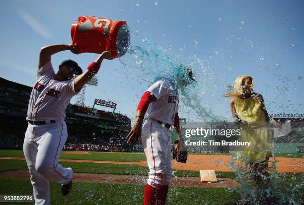 Hector Velazquez of the Boston Red Sox douses Mookie Betts as he is interviewed after the Boston Red Sox defeated the Kansas City Royals 5-4 at...