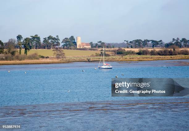 Ramsholt church and moored yacht seen from across River Deben, near Kirton Creek, Suffolk, England, UK.