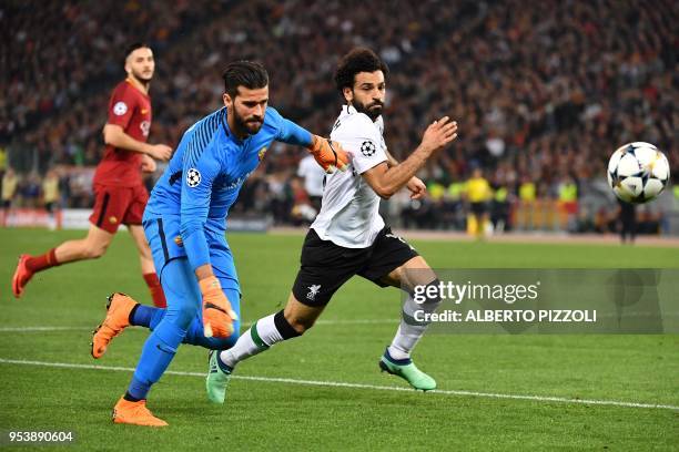 Roma's Brazilian goalkeeper Alisson vies with Liverpool's Egyptian midfielder Mohamed Salah during the UEFA Champions League semi-final second leg...