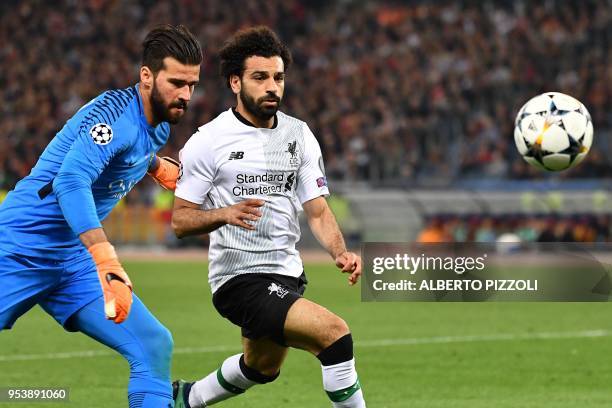 Roma's Brazilian goalkeeper Alisson vies with Liverpool's Egyptian midfielder Mohamed Salah during the UEFA Champions League semi-final second leg...