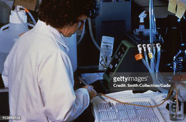 Centers for Disease Control Special Pathogens Branch scientist performing an Enzyme-Linked ImmunoSorbent Assay test on suspected Hantavirus samples,...