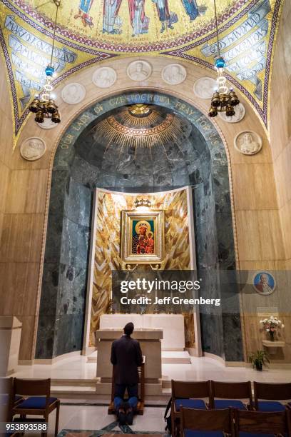 Washington DC, Basilica of the National Shrine of the Immaculate Conception, man Kneeling at altar.