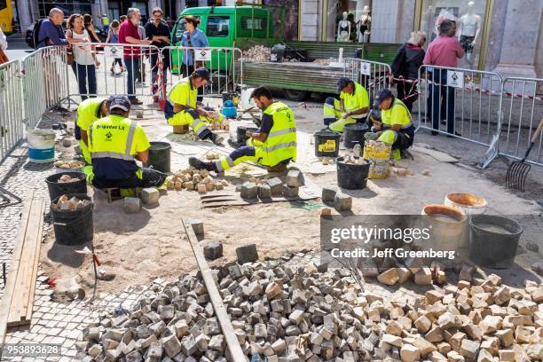 Portugal, Lisbon, Restauradores Square, cobblestone repair workers.