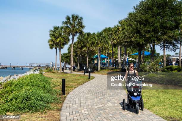 Georgia, St. Simons Island, Neptune Park, waterfront, Woman and stroller on walkway.