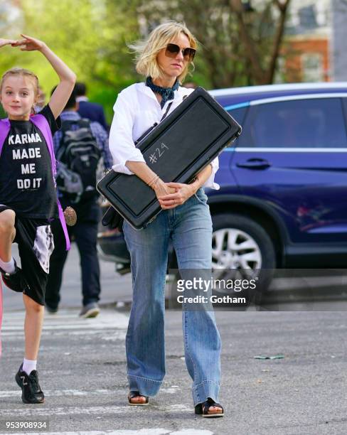 Naomi Watts holds a musical instrument when walking to school with Alexander Schreiber on May 2, 2018 in New York City.