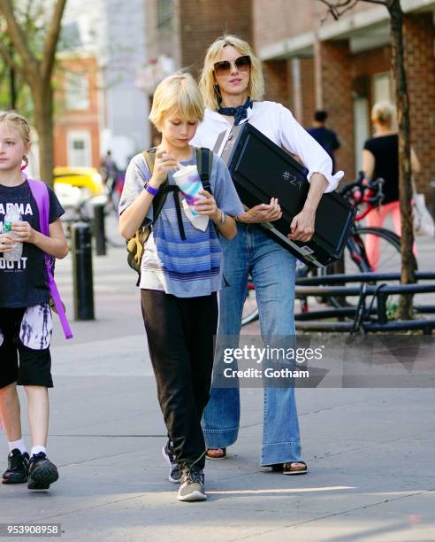 Naomi Watts holds a musical instrument when walking to school with Alexander Schreiber on May 2, 2018 in New York City.