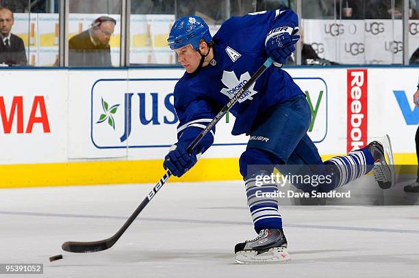 Mike Komisarek of the Toronto Maple Leafs takes a shot against the Montreal Canadiens during their NHL game at the Air Canada Centre December 26,...