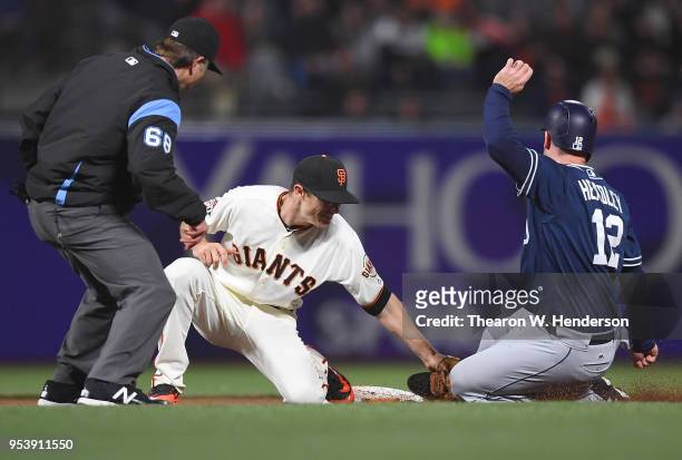 Chase Headley of the San Diego Padres gets tagged out at second base by Kelby Tomlinson of the San Francisco Giants in the top of the six inning at...