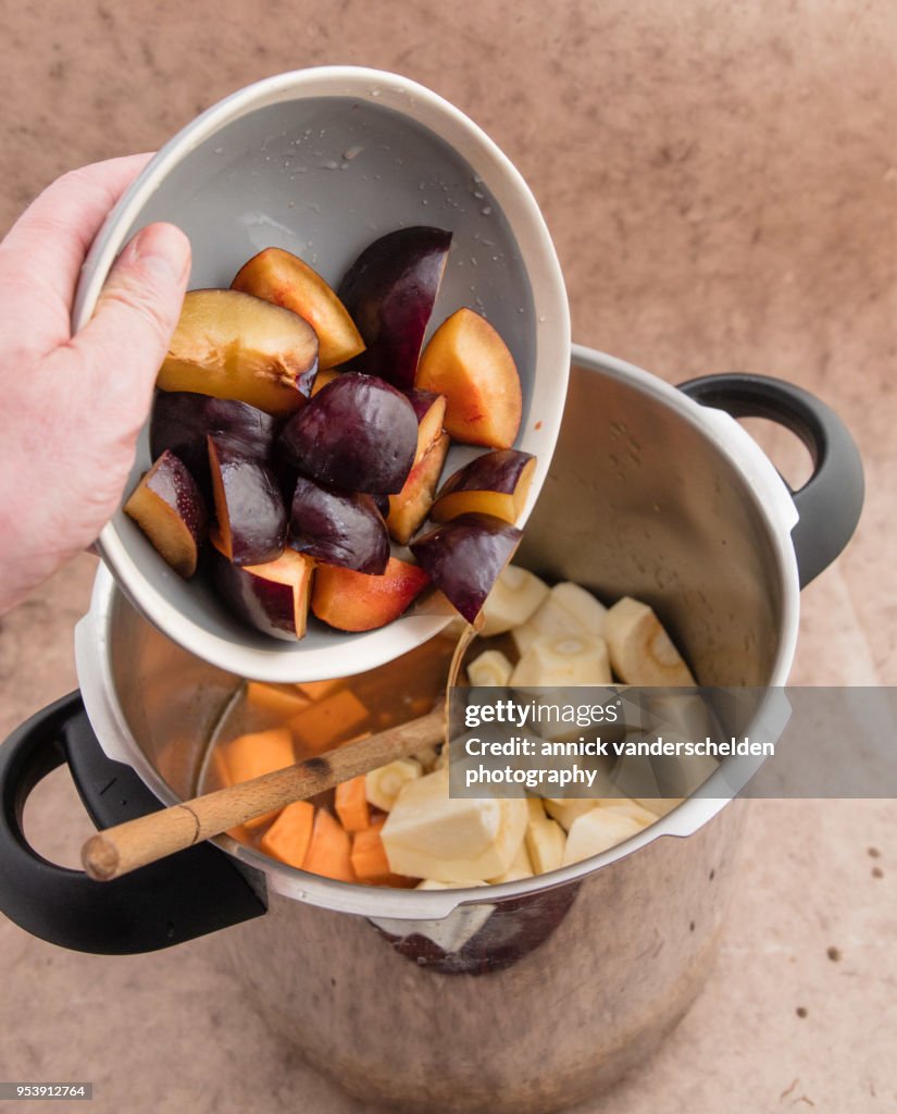 Adding black amber plums in pressure cooker.
