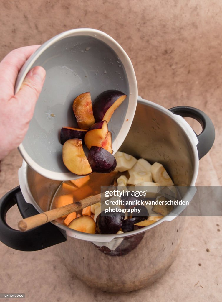Adding black amber plums in pressure cooker.