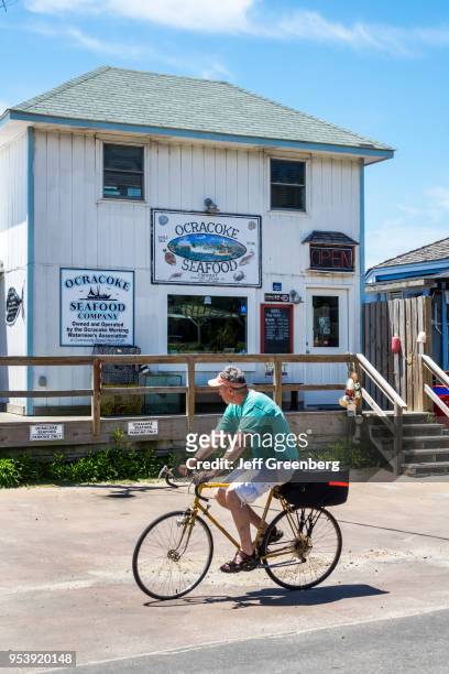 North Carolina, Ocracoke Island, Ocracoke Seafood Company, bicyclist going by.