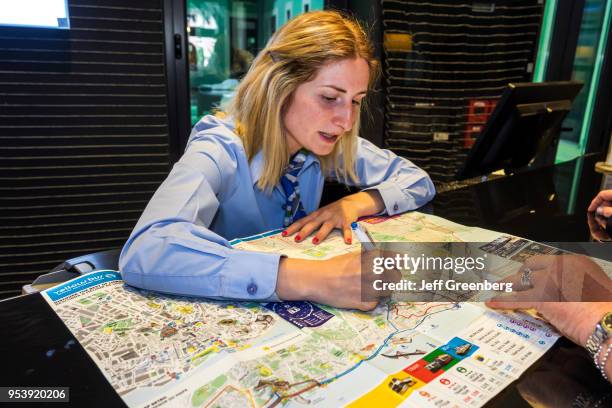 Portugal, Lisbon, Rua Alexandre Herculano, Holiday Inn Express, desk clerk giving directions on map.