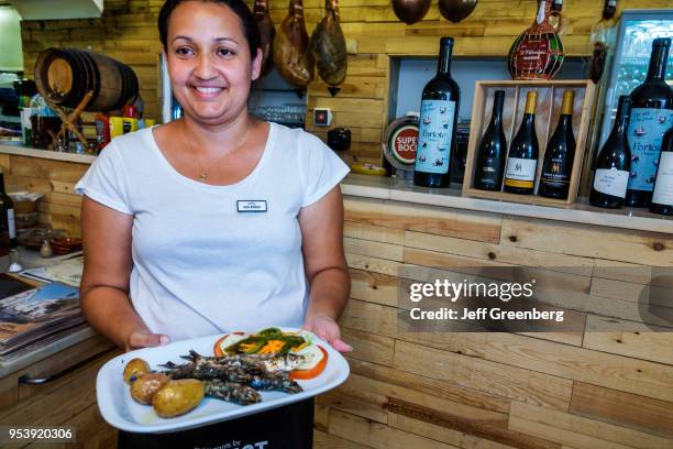 Portugal, Lisbon, Bairro Alto, Restaurante Adega de Sao Roque, restaurant waitress carrying food plate.