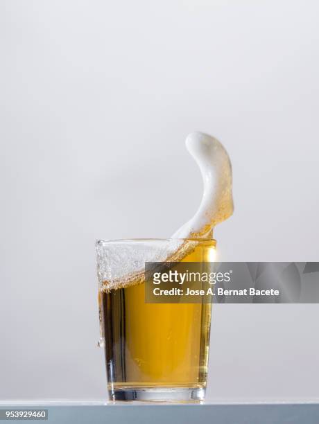 impact of a glass with beer that falls down on the table. - beer bubbles stock pictures, royalty-free photos & images