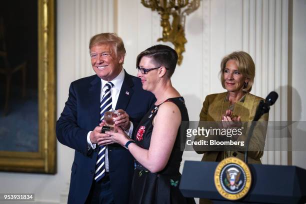 President Donald Trump presents the National Teacher of the Year award to Mandy Manning, center, next to Betsy DeVos, U.S. Secretary of education,...