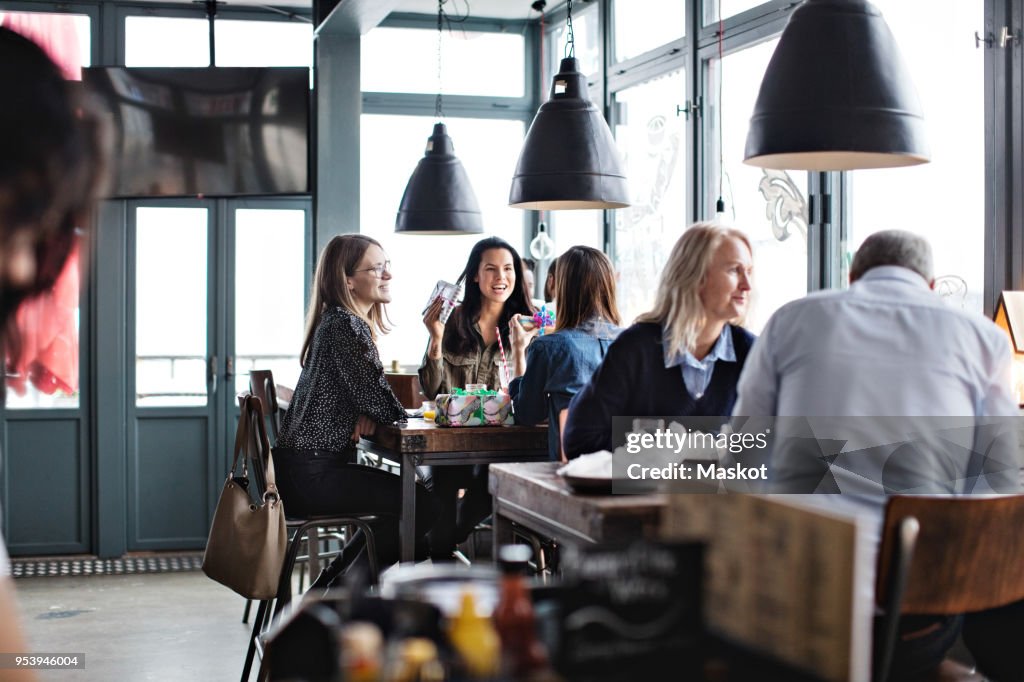 Customers enjoying while sitting at restaurant
