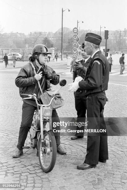 Deux policiers de la brigade de circulation de Paris contrôle le conducteur d'une mobylette à Paris le 12 avril 1988, France.