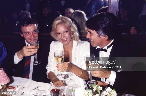 Sylvie Vartan en compagnie de Michel sardou et Tony Scotti lors d'une soirée à Paris le 4 septembre 1984, France.