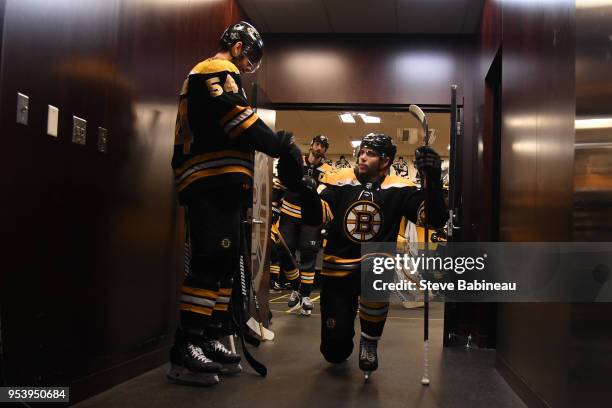Adam McQuaid and Jake DeBrusk of the Boston Bruins fist bump before warm ups before the game against the Tampa Bay Lightning in Game Three of the...