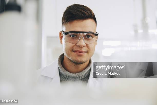 portrait of confident young chemistry student wearing eyewear in laboratory - chemistry class stock pictures, royalty-free photos & images