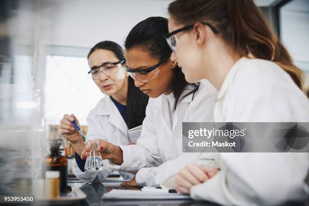 female chemistry teacher explaining to young multi-ethnic students in laboratory - chemistry class stock pictures, royalty-free photos & images