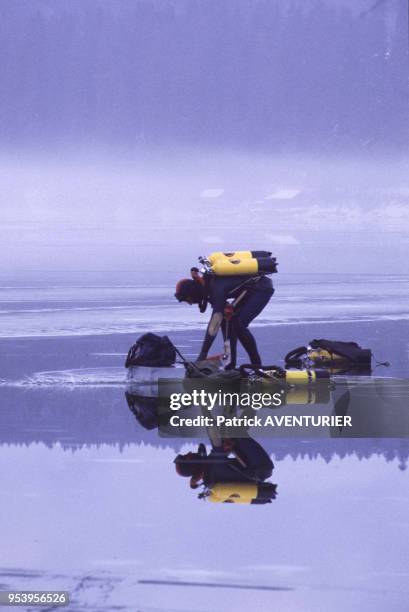 Plongeurs du Groupe d'Intervention de la Gendarmerie Nationale à l'entrainement en hiver dans le lac gelé de Malbuisson en janvier 1985, France.